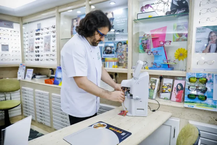 Óptico de Ópticas Fausto trabajando con maquinaria de precisión para personalizar lentes