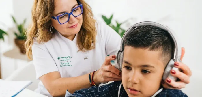 Óptica de Ópticas Fausto adaptando unos auriculares a un niño